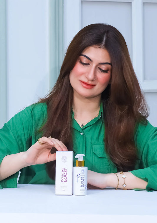 Sana Abid holding Bounce & Boost Lavender Conditioner and its packaging, showcasing luxurious hair care.