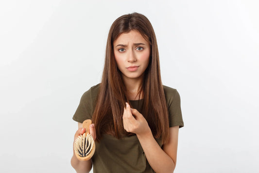 Why Sulfate-Free Shampoo Is Better for preventing hair damage and breakage, woman holding hairbrush with concern.