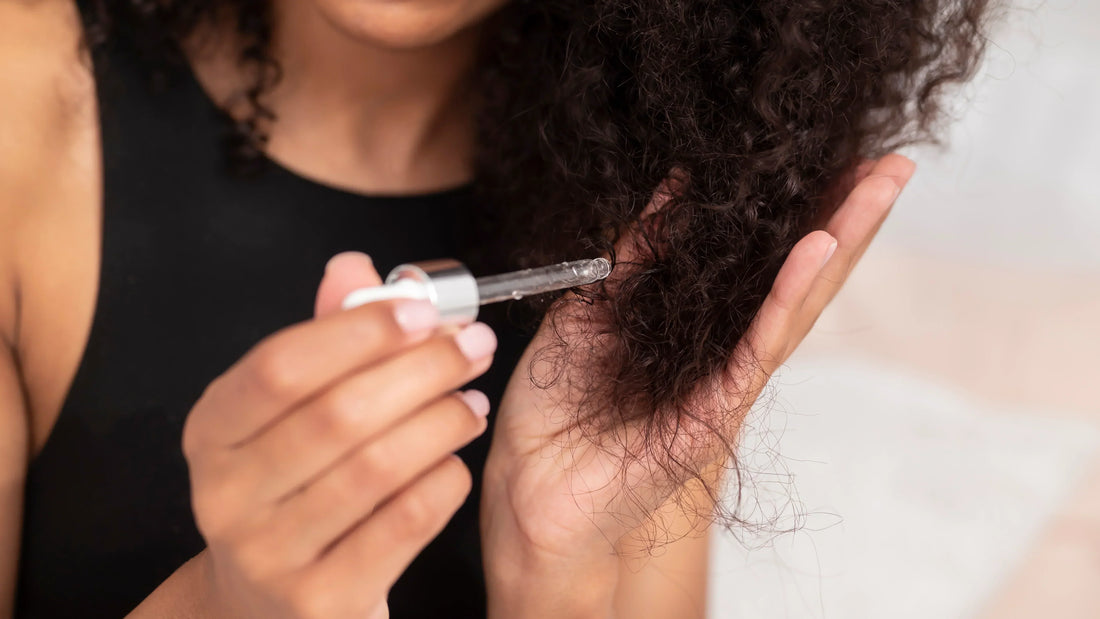 A person applying hair serum to curly hair, highlighting common hair serum mistakes you should avoid.