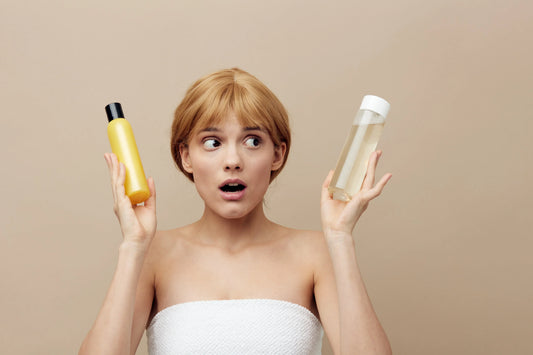 Woman comparing two hair care products, highlighting the importance of sulfate-free shampoo for colored hair.