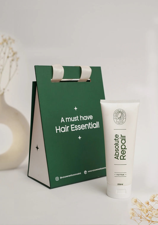 Absolute Repair Mask in a tube with green packaging emphasizing hair essentials.
