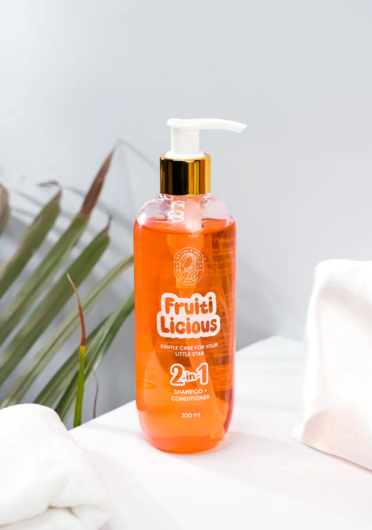Fruitilicious Tear Free Kids Shampoo 2-in-1 in a clear bottle with a pump, surrounded by soft towels.