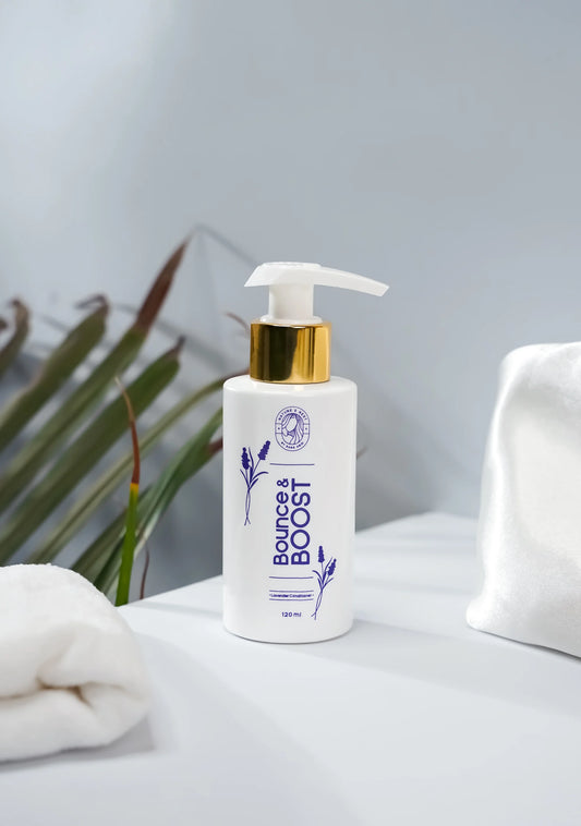 Bounce & Boost Lavender Conditioner in a white pump bottle with a gold lid on a minimalistic background.